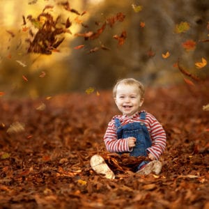 Location portrait photography of child in autumn leaves
