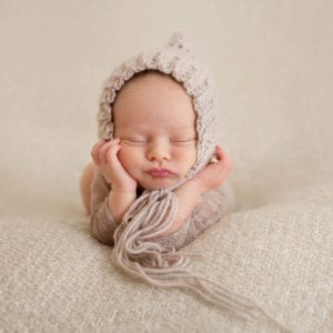 Cute newborn baby in wooden bonnet