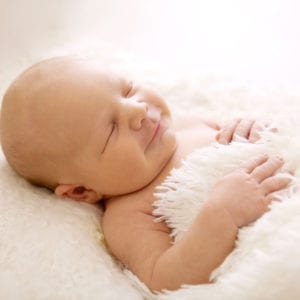 Contented newborn asleep in photograph